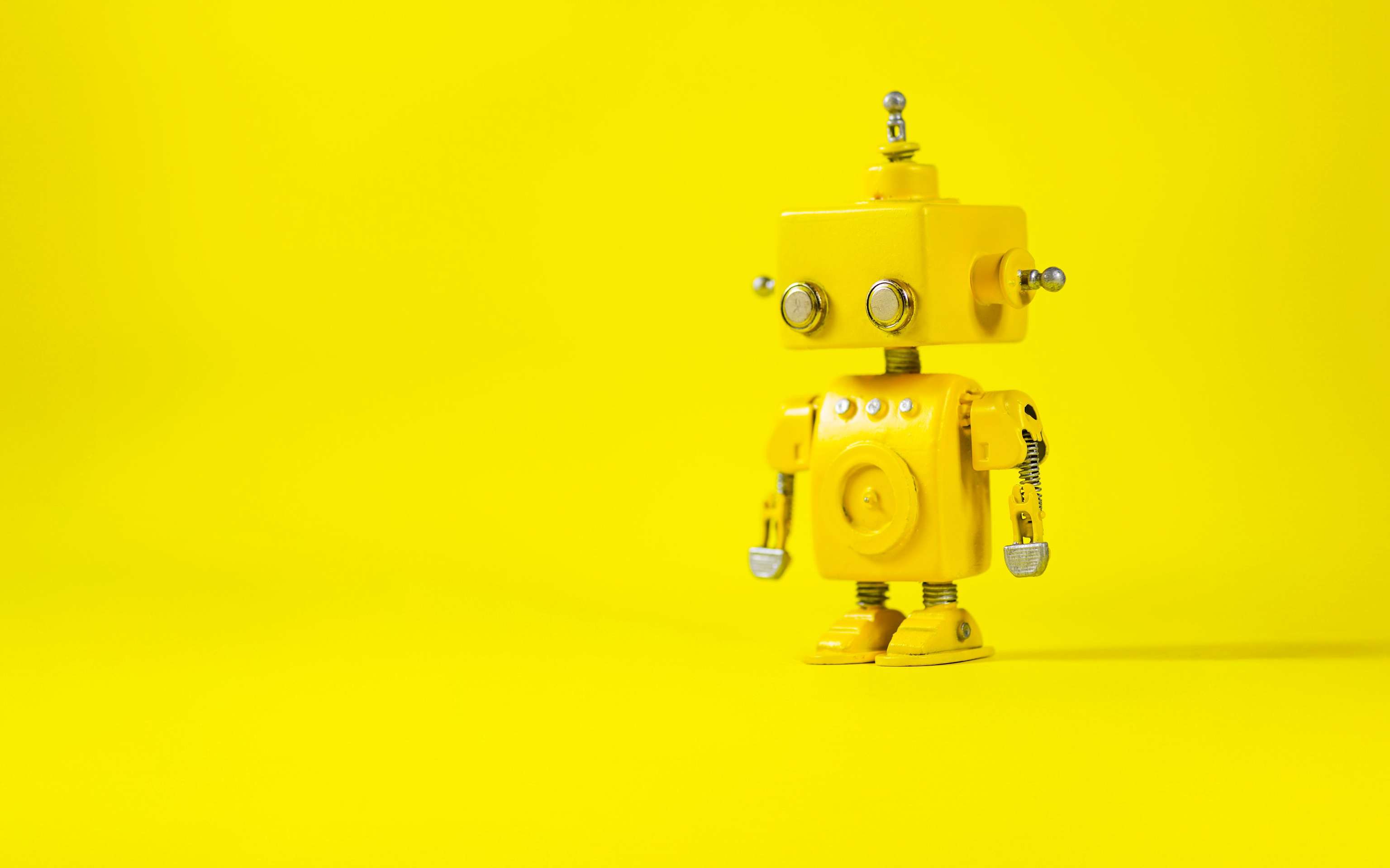 Kleiner gelber Roboter steht in einem gelben Raum - KI generiert Kleiner gelber Roboter steht in einem gelben Raum