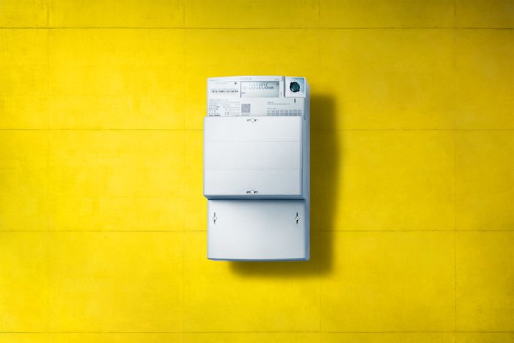 Ein digitaler Stromzähler ist ein einfacher Zähler mit digitaler Anzeige Digitaler Stromzähler, eine moderne Messeinrichtung, an gelber Wand