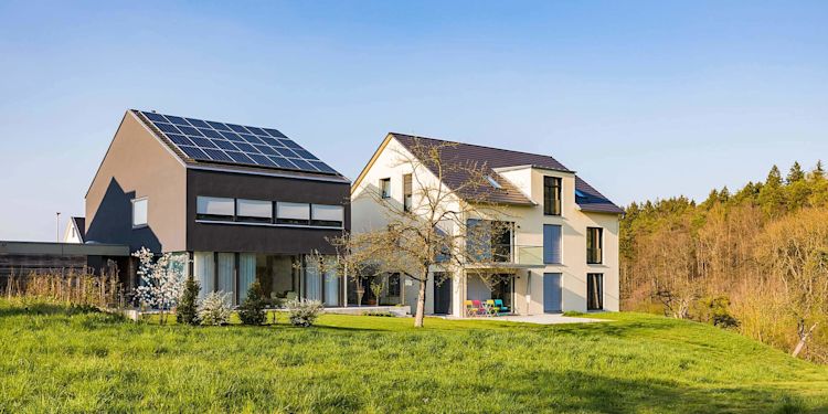 Solarstrom lokal mit Nachbarn teilen – neu über Energy Sharing Modernes Einfamilienhaus mit Photovoltaik-Anlage steht neben Haus ohne Photovoltaik-Anlage