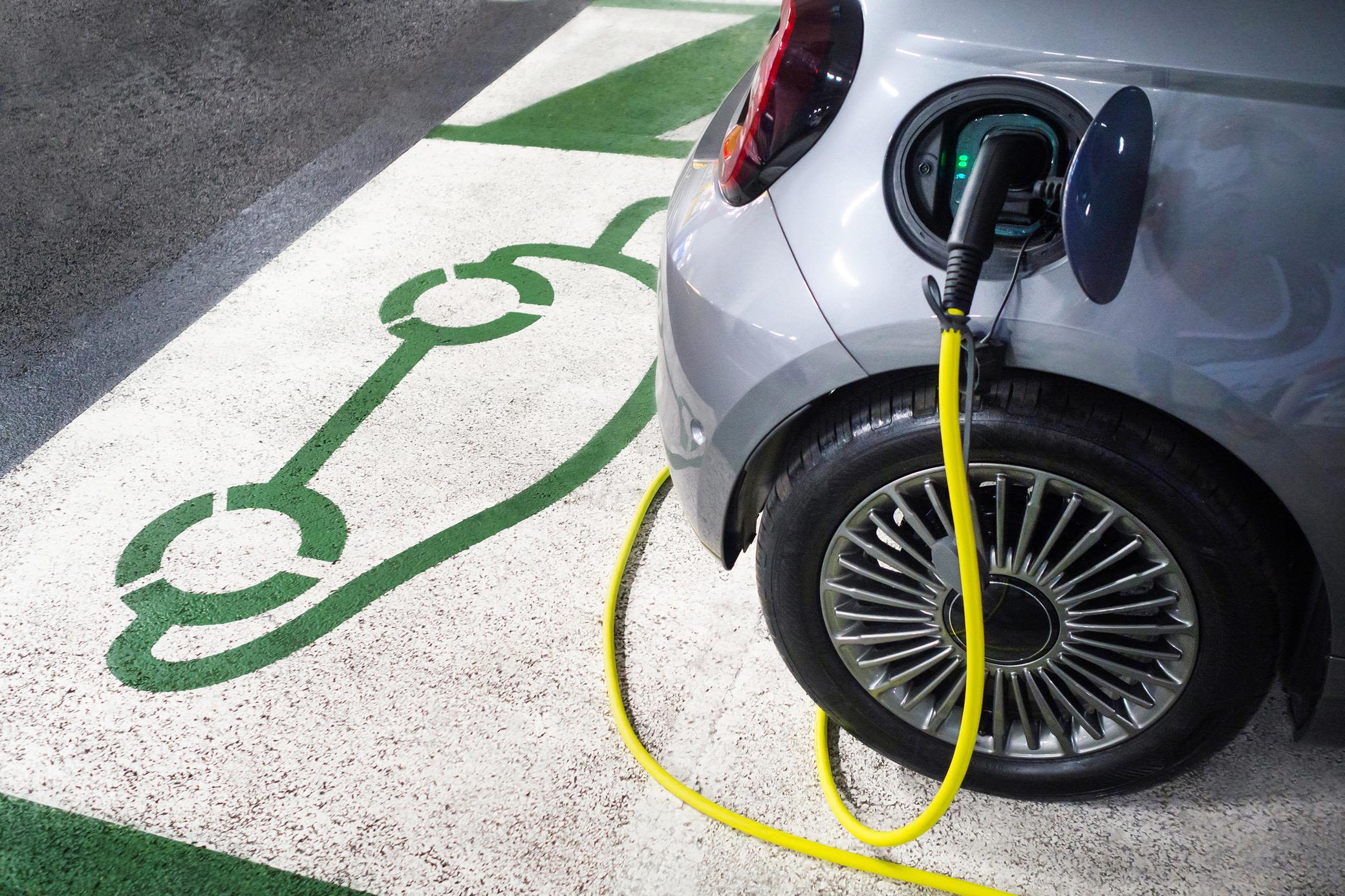 Schnell das Elektroauto beim Einkaufen laden Parkendes E-Auto beim Ladevorgang