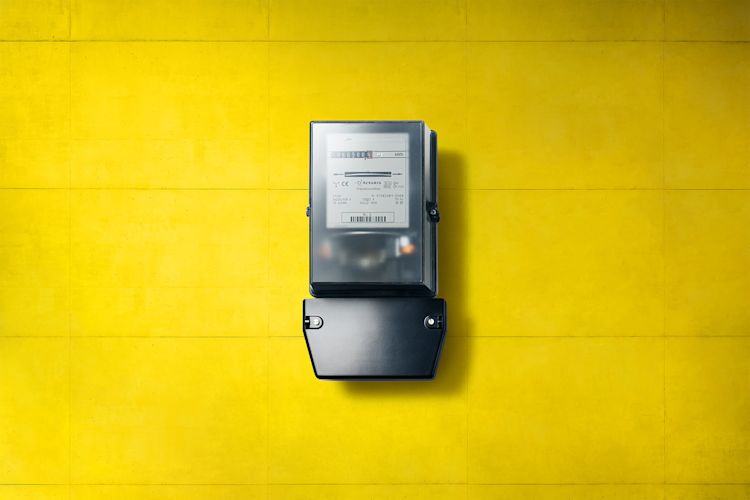 Die schwarzen, analogen Stromzähler sind in einigen Jahren Geschichte Analoger schwarzer Stromzähler, Ferraris-Zähler, an gelber Wand
