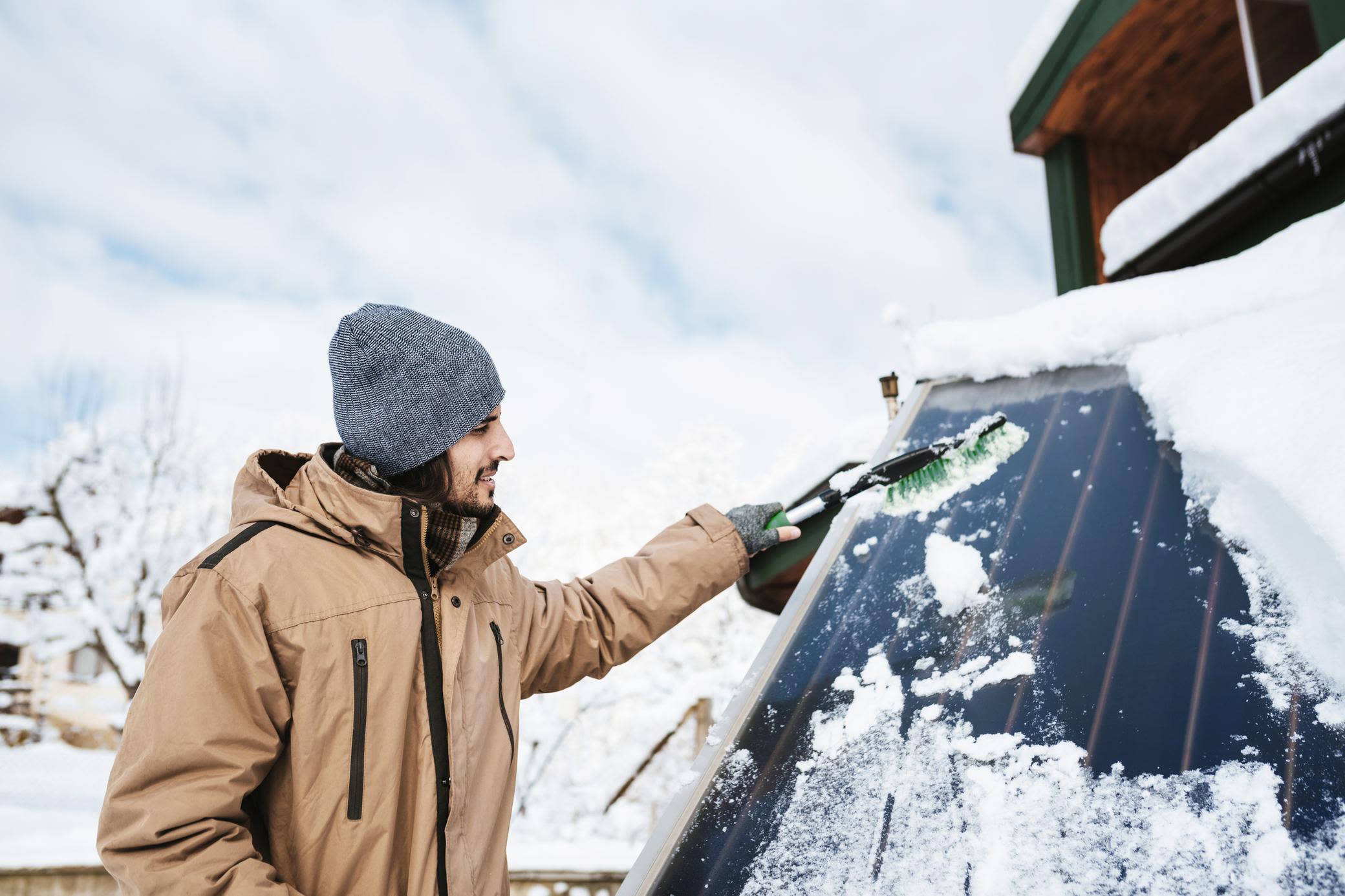 Nachteil. Im Winter produziert die Solaranlage weniger Strom Mann befreit im Winter eine Solaranlage von Schnee