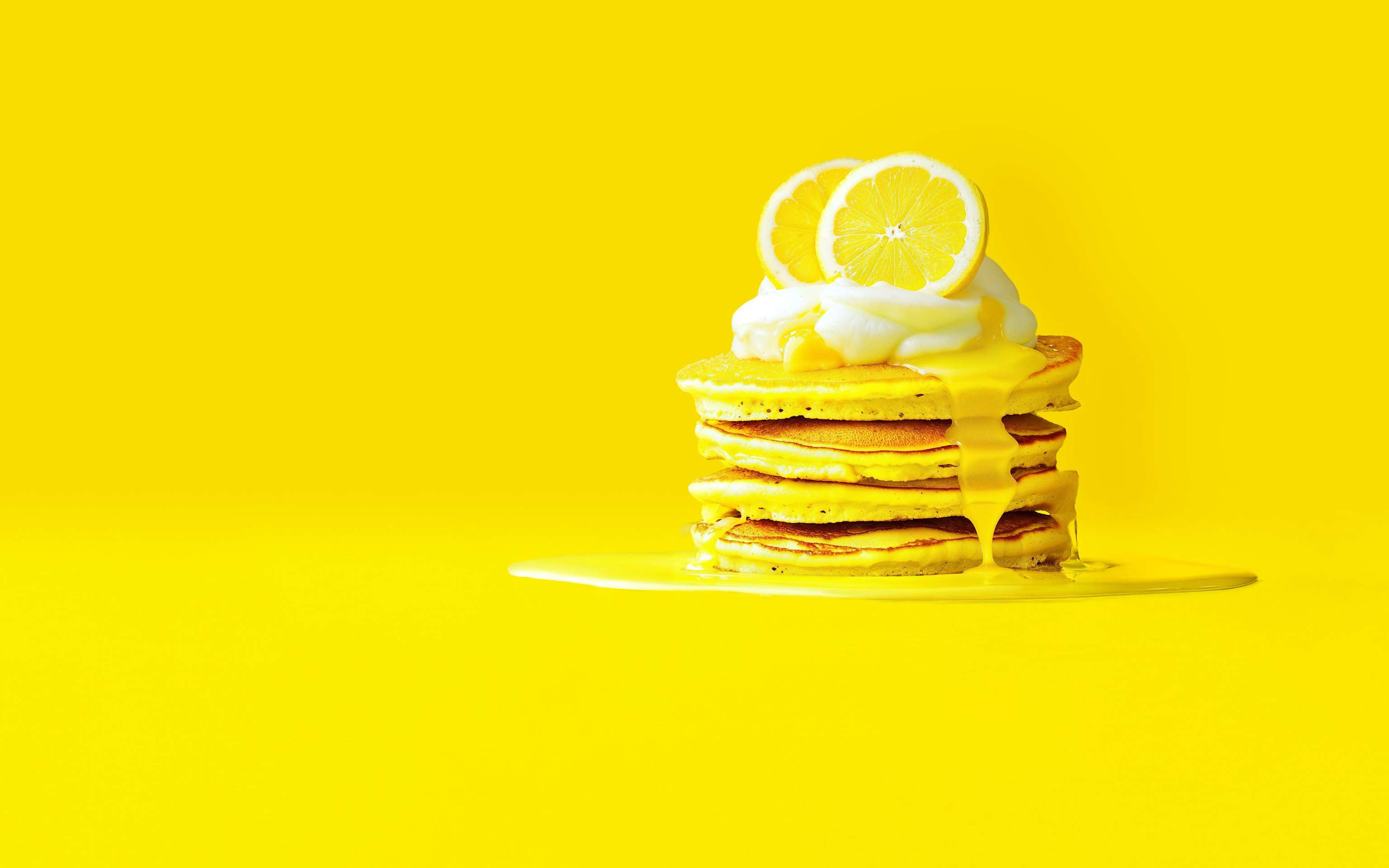 Pfannkuchenstapel mit Zitronenscheiben und weißer Soße auf gelbem Untergrund - KI generiert Pfannkuchenstapel mit Zitronenscheiben und weißer Soße auf gelbem Untergrund - KI generiert