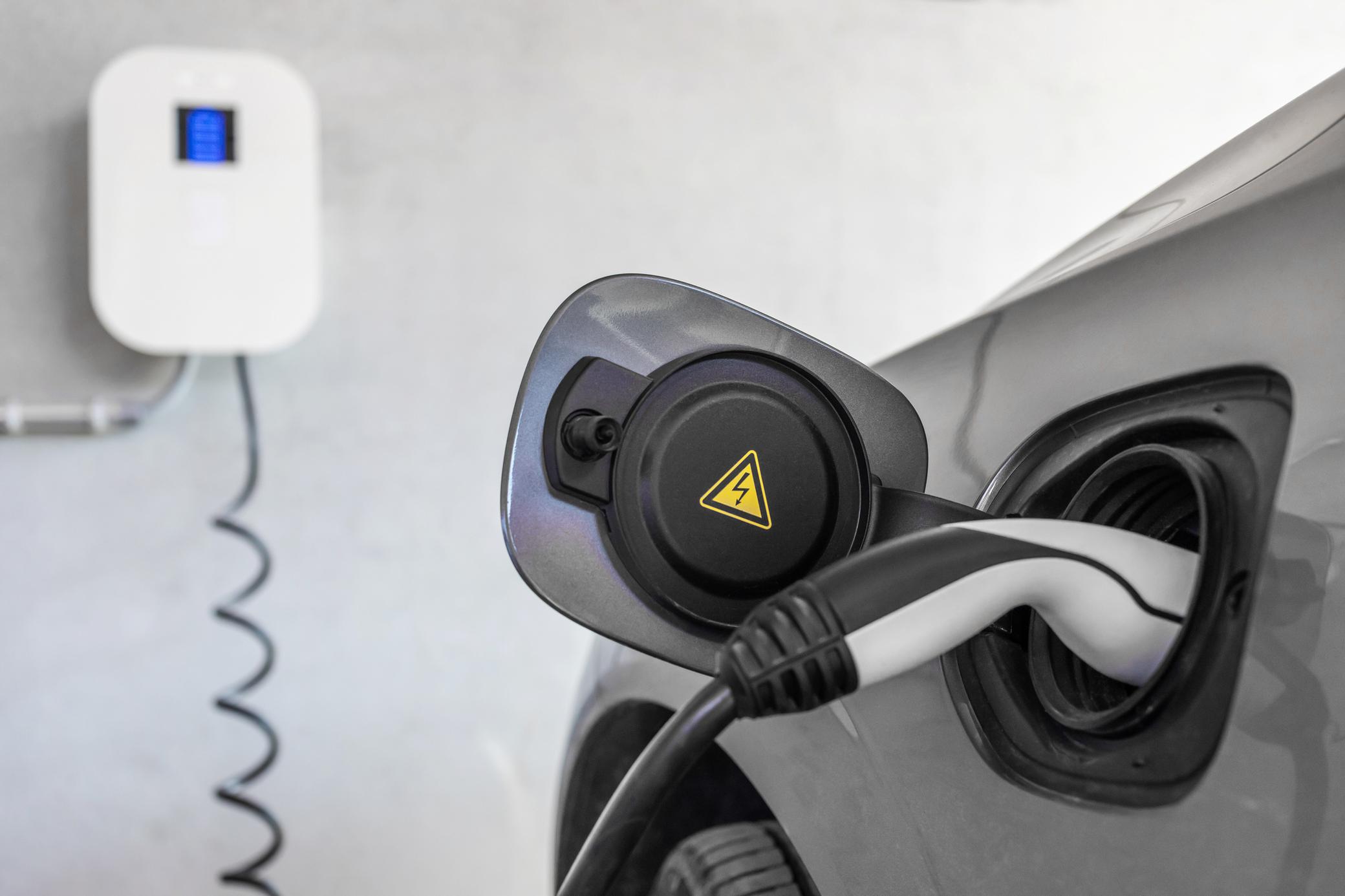 Elektrisches Auto lädt an einer Wallbox zuhause.
