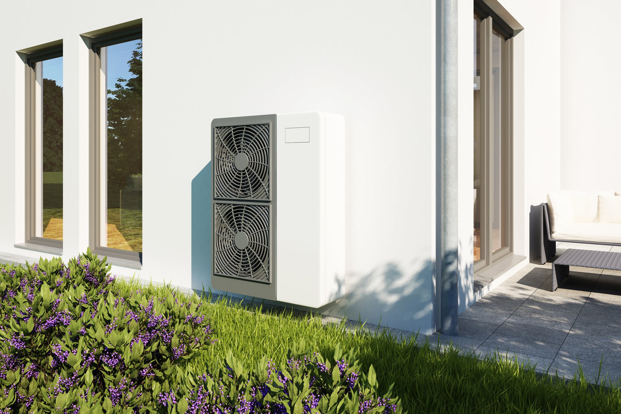 Mit Wärmepumpen nutzen wir mehr erneuerbare Energien bei der Wärmeversorgung Eine Wärmepumpe steht vor heller Hauswand im Garten