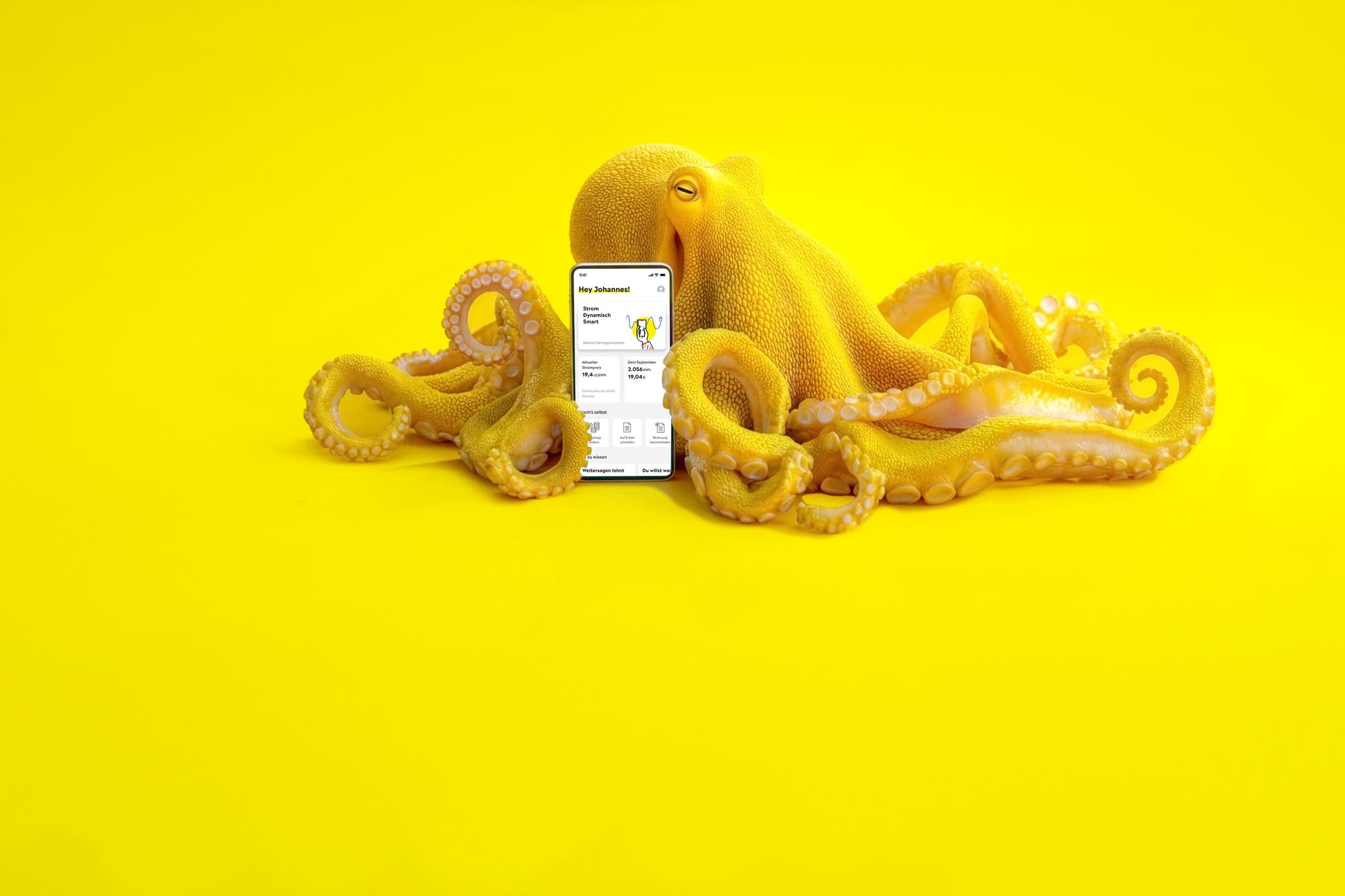 Der dynamische Tarif von Yello bringt mehr Flexibilität in dein Zuhause Gelber Oktopus mit einem Smartphone mit Yello App auf dem Bildschirm - KI generiert