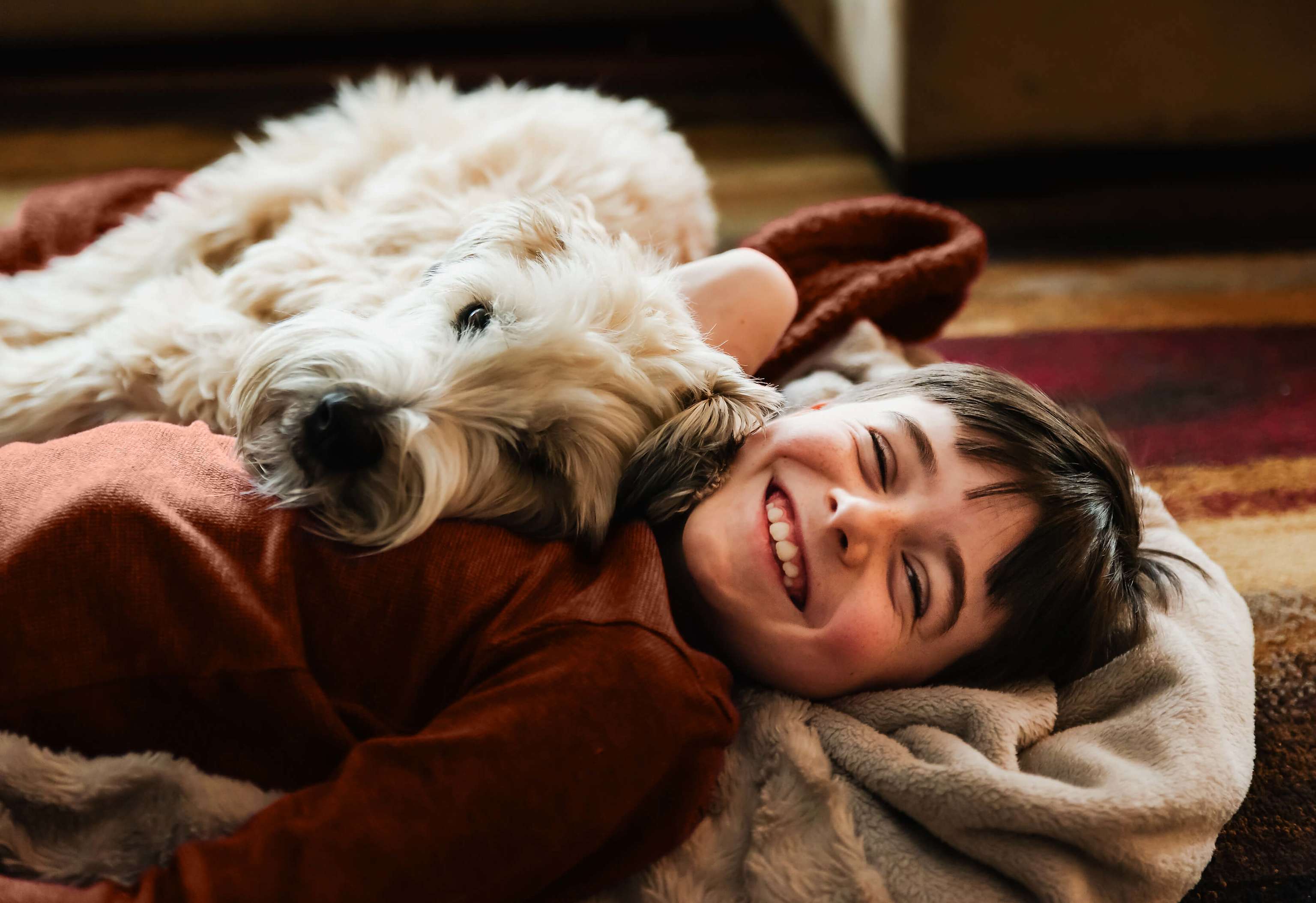 Ein Junge kuschelt mit deinem Hund und lächelt in die Kamera. Ein Junge kuschelt mit deinem Hund und lächelt in die Kamera.