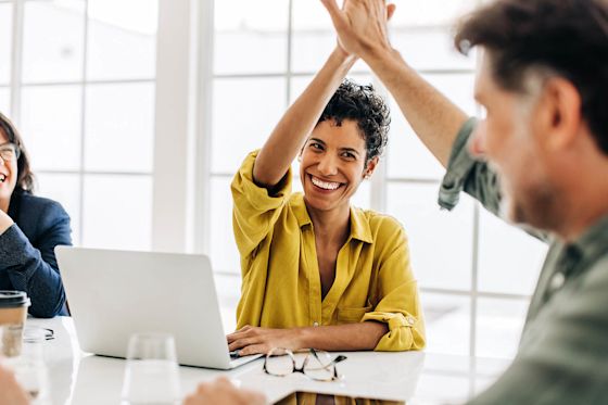 Erfolgreiche Zusammenarbeit im Büro für mehr gute Energie Frau und Mann geben sich High Five im Büro