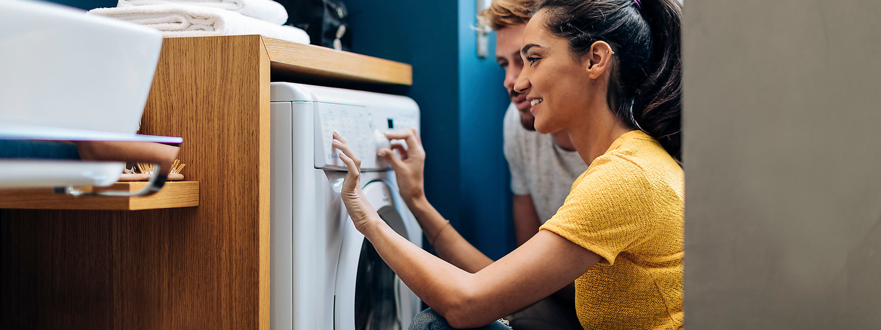 Energieeffiziente Haushaltsgeräte sparen dir Strom Junges Paar befüllt zusammen eine Waschmaschine