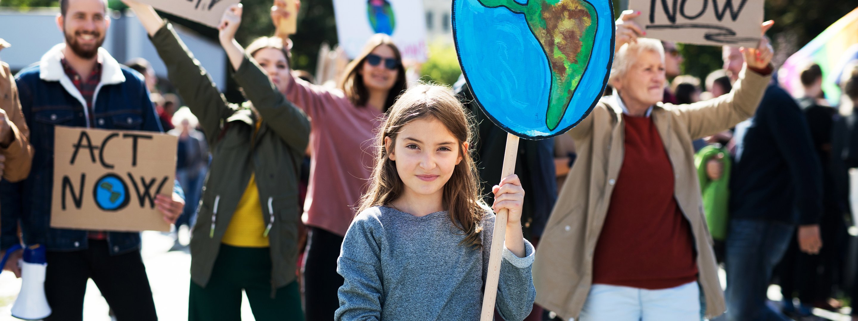 Mädchen hält Abbildung der Erde auf einer Klima-Demo in die Luft