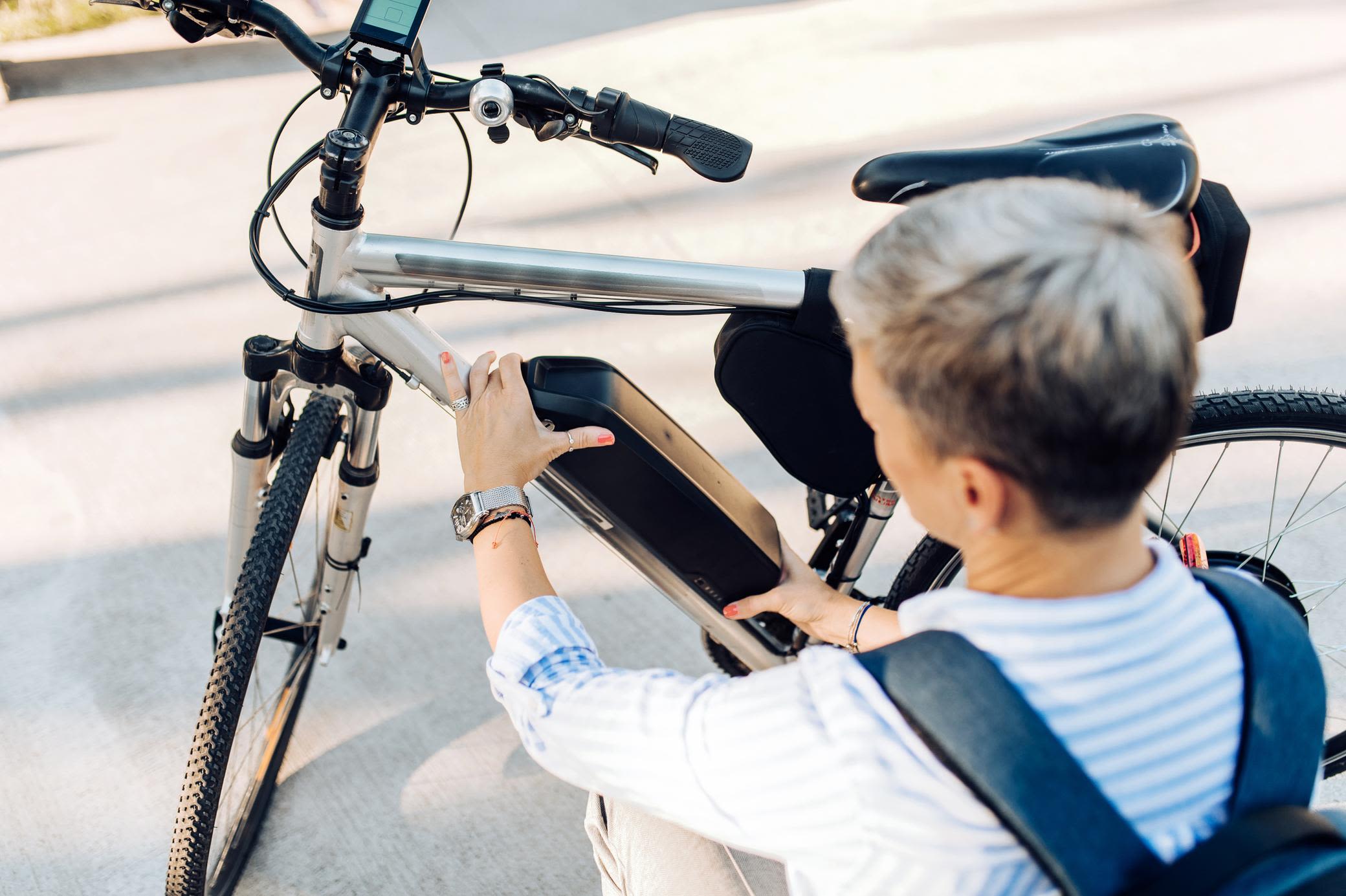 E-Bike gebraucht kaufen: Gut für dein Geldbeutel und die Umwelt Frau wechselt die Batterie ihres E-Bike