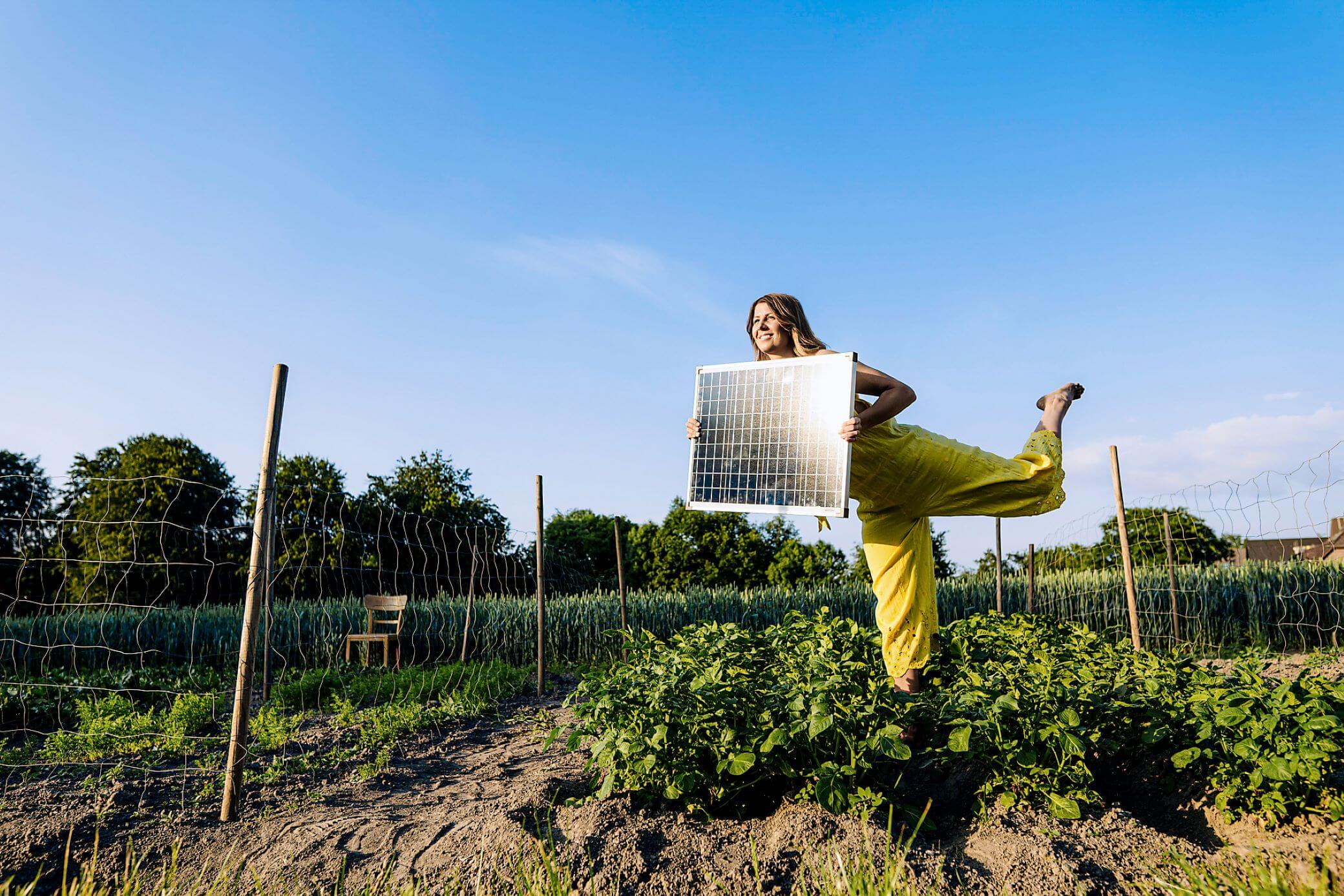Frau mit Solarmodul in den Händen im Garten