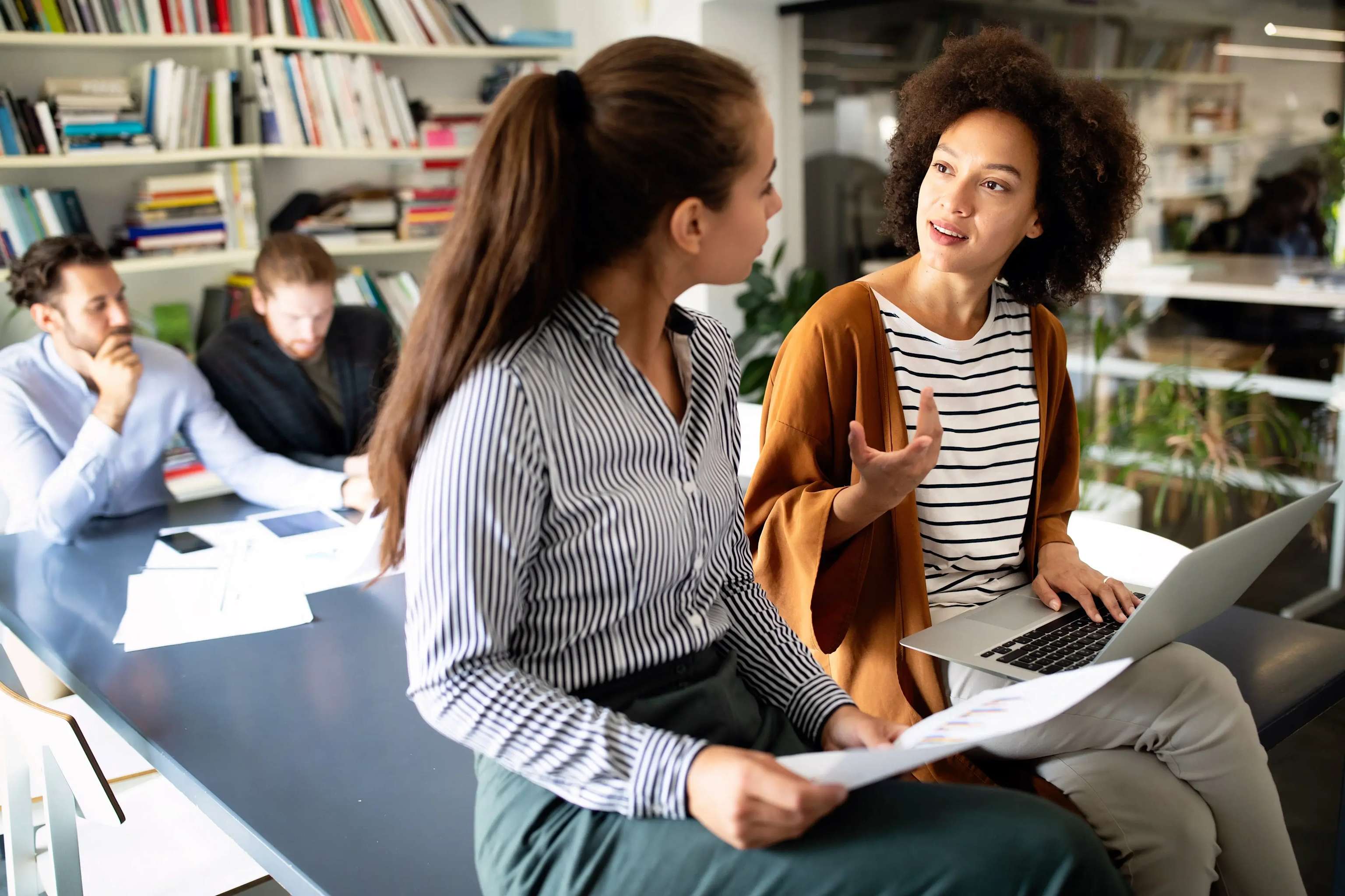 Zwei Frauen unterhalten sich in der Bibliothek Zwei Frauen unterhalten sich in der Bibliothek
