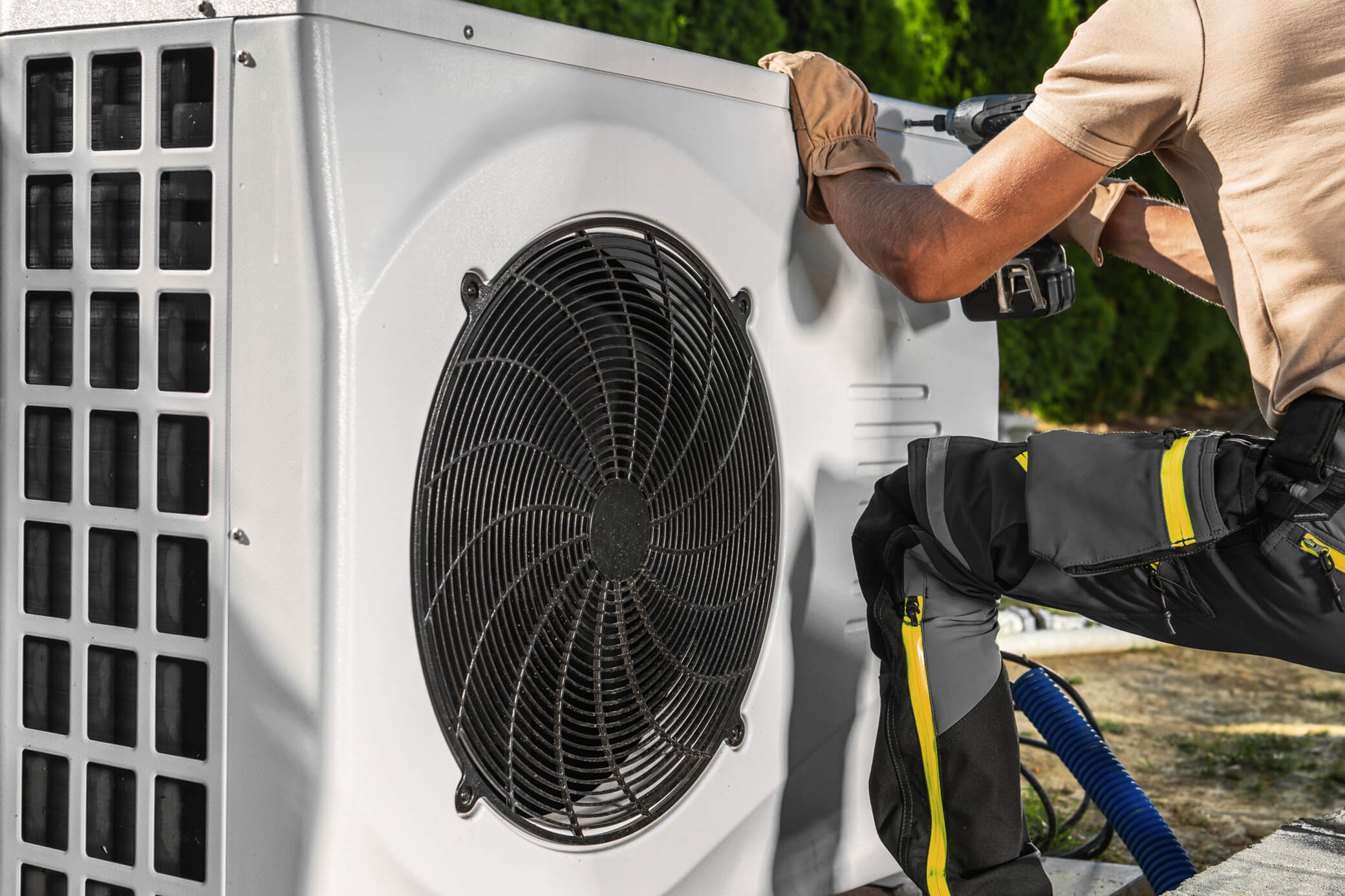 Mit der Installation einer Wärmepumpe Heizkosten sparen Installateur schließt eine Wärmepumpen-Heizung an