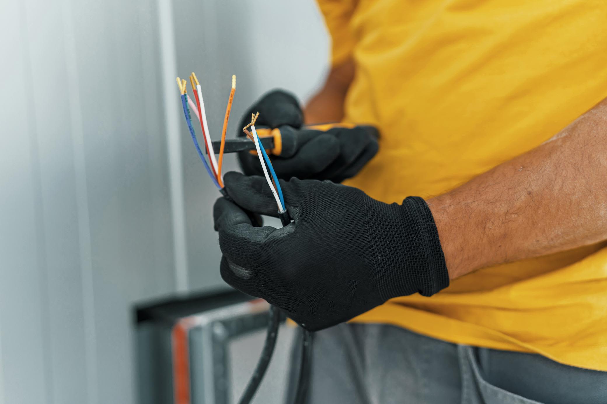 Unsere Stromversorgung basiert vor allem auf Wechselstrom Elektriker schneidet ein elektrisches Kabel zu