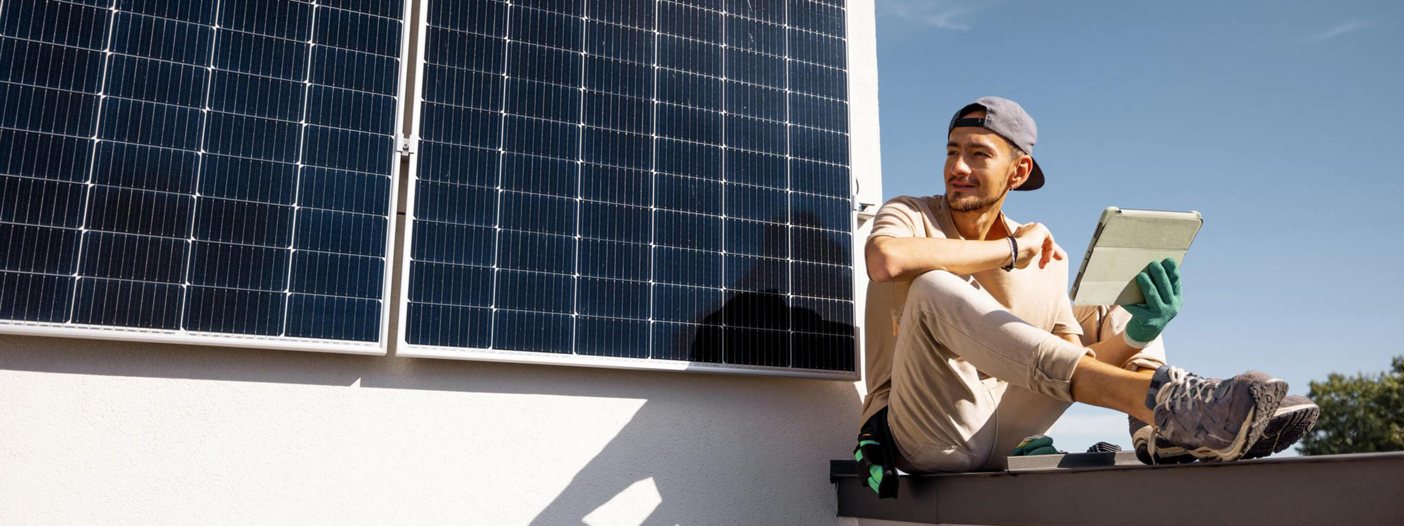Solarmodule gibt es in vielen verschiedenen Arten Mann prüft Solarmodule auf einem Dach mit Tablet