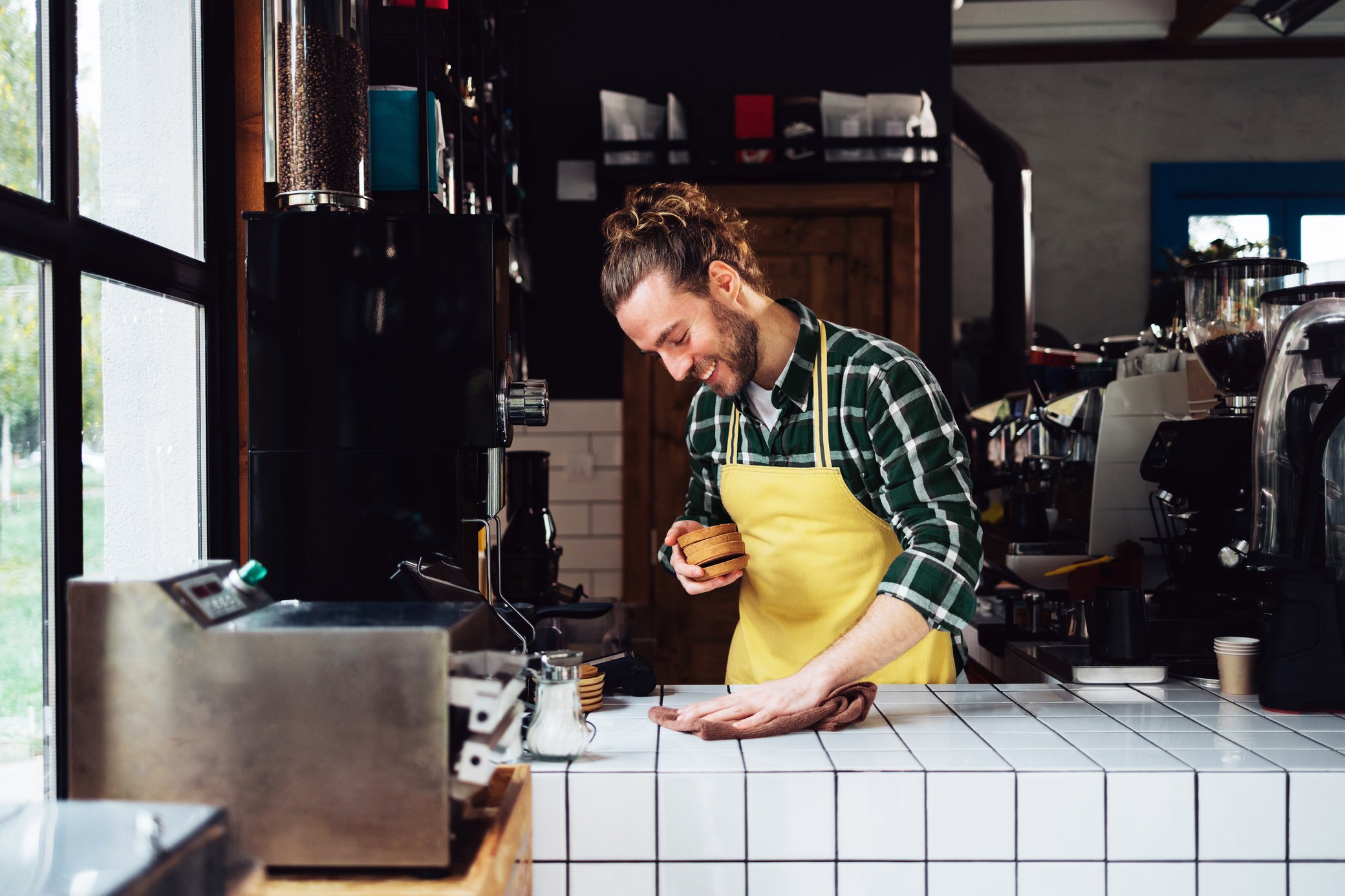 Mann im Cafe vor Barista Maschinen bereitet Kaffee für Kunden und Gäste vor