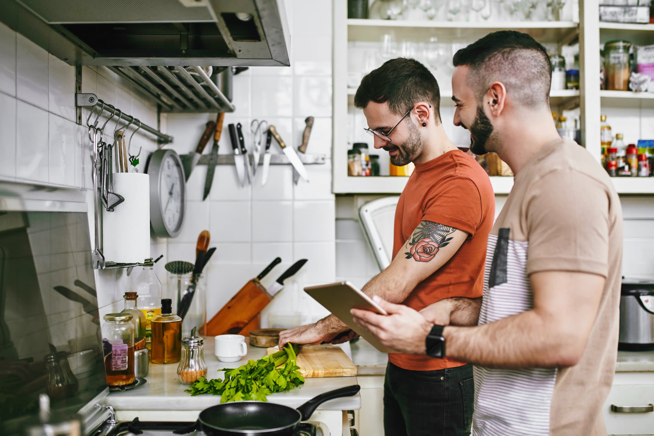 Smarte Geräte unterstützen dich auch in der Küche Zwei Männer beim gemeinsamen Kochen mit Tablet in der Küche