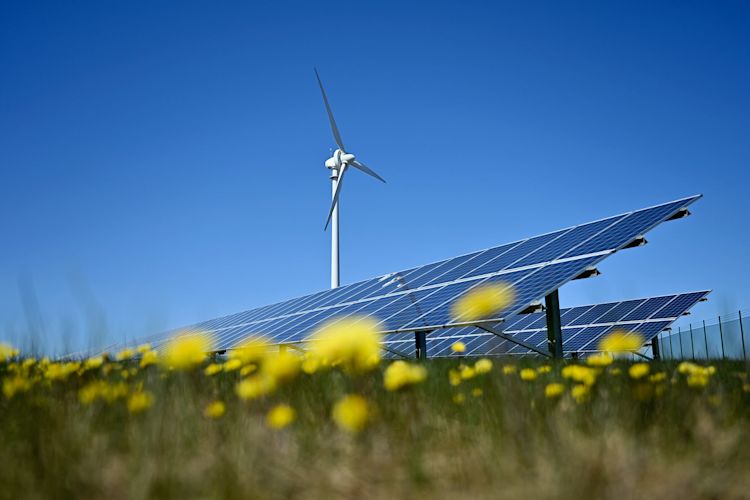 Erneuerbare Energien sorgen umweltfreundlich für grünen Strom Eine Windenergieanlage und Solarpark im Blumenfeld